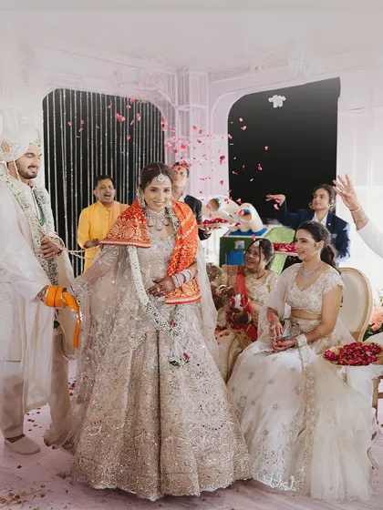 A candid moment from the wedding ceremony, filled with smiles and a shower of rose petals.