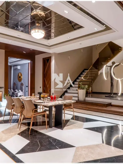 This dining lobby is an experience in modern luxury. The geometric black and white marble flooring creates a bold statement, while the mirrored ceiling reflects the light from the chandelier, adding depth and glamour to the space.