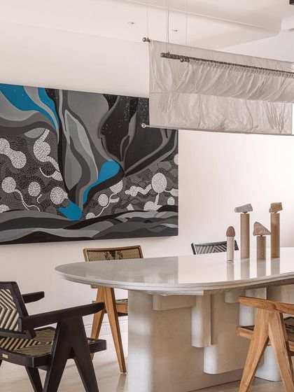 The dining space at Kanso House, where art and design converge. A stunning 'Starry Nights' inspired painting and a sculptural fabric light create an atmosphere of engrossing beauty, perfect for intimate dinners and shared moments.