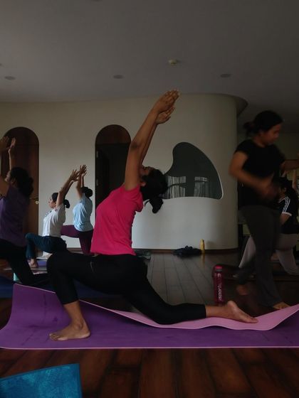 A student practices Anjaneyasana (Low Lunge), a powerful hip flexor stretch. Our workshops often focus on foundational poses to build a strong and flexible base.