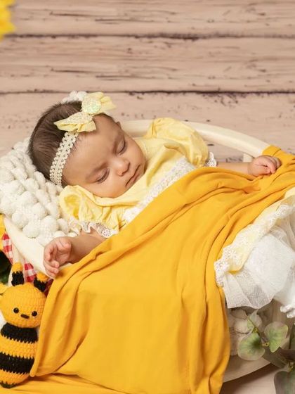 A sweet newborn sleeping in a basket as part of our sunflower and bee theme, showing how I can incorporate themes even for the tiniest clients.