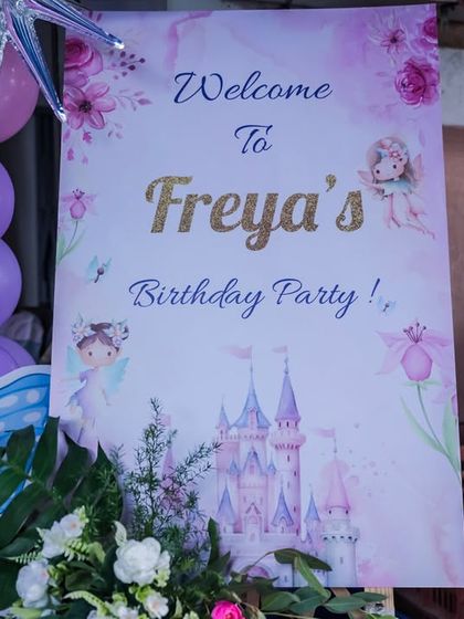 A close-up of the beautifully designed welcome sign for Freya's birthday party, featuring a watercolor castle and fairy illustrations.