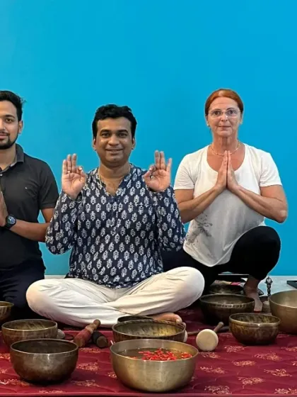 A group of students and I pose together after a sound healing workshop, surrounded by the instruments that guided our practice.