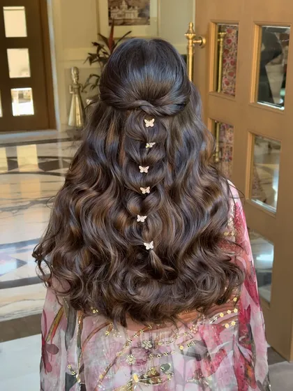 For a more whimsical and playful vibe, especially for a Mehendi or Haldi, I love incorporating fun accessories. This half-up style features a delicate butterfly braid, creating a look that is youthful, fresh, and full of personality.