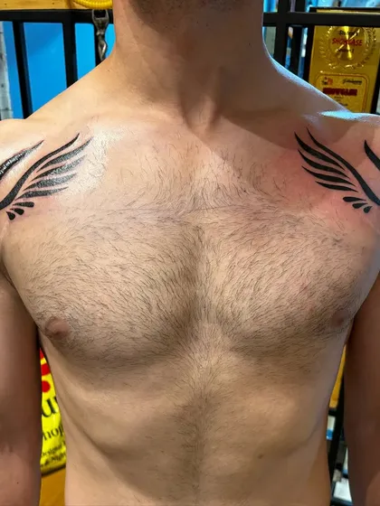 Another view of the chest cover-up tattoo, showing how the wings are placed to create a strong, masculine aesthetic.