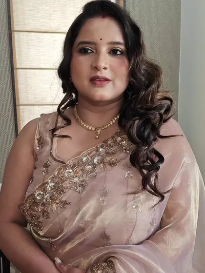 A lovely party makeup look with soft, side-swept curls. This hairstyle is perfect for an organza saree, creating a very soft and feminine silhouette.
