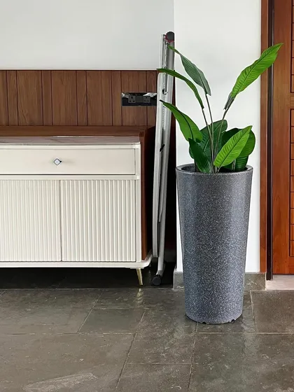 This artificial Bird of Paradise plant in a grey stone-finish planter adds a tropical feel to this home entrance without any need for watering or sunlight.