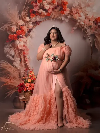 A portrait of a queen. The tiara and the stunning peach gown make this mama-to-be look absolutely regal in the boho floral ring setup.