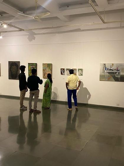 A group of four visitors discussing a painting.