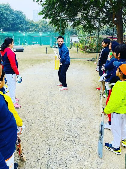 An attentive group of young cricketers listening to their coach. We foster a disciplined and respectful environment where players are eager to learn.