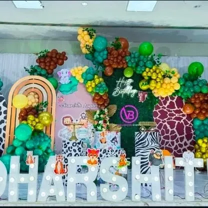 A vibrant jungle-themed birthday party. This setup uses animal print backdrops, lots of green and yellow balloons, and cute animal cutouts.
