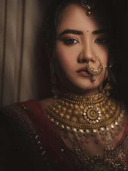 A close-up of this stunning Garhwali bride. The focus is on her expressive eyes and the intricate details of her traditional jewelry, creating a powerful and captivating image.