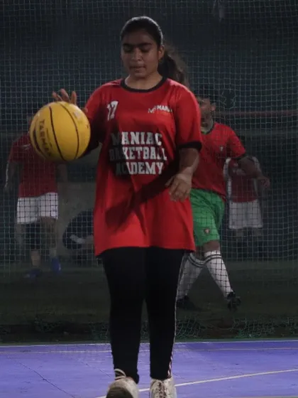 A female player in her Maniac jersey dribbles down the court. We shape passion into discipline, building champions on and off the court.