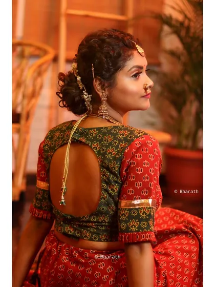 A back-profile shot that highlights the keyhole back design of the blouse and the traditional hairstyle. This is a great example of showcasing specific design details.