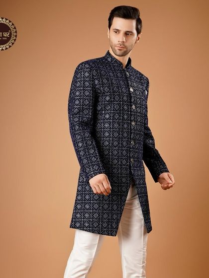 A sophisticated blue patterned sherwani paired with white trousers, offering a classic yet visually interesting look.