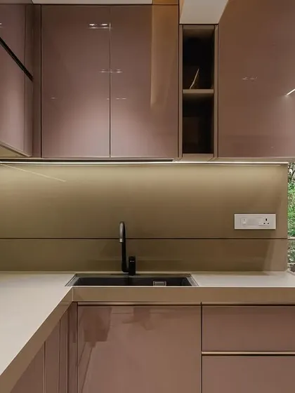 The epitome of elegance, this kitchen in Malad showcases a full back-painted glass finish in a rose gold shade, complemented by a sleek G handle and premium hardware from Hafele and Blum.