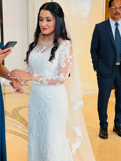 The bride Michelle looking elegant and serene in her beautiful lace gown and long veil.
