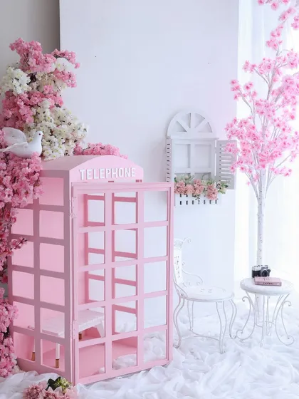The full picture. This wider shot shows how the pink telephone booth, vintage chair, and cherry blossom tree come together to create a complete, dreamy scene. I have a variety of props to build the perfect set.