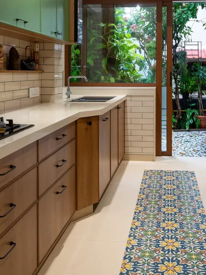 This view shows how the kitchen opens up to an outdoor space, blurring the lines between inside and out. The large window brings in abundant natural light and a sense of tranquility from the garden.