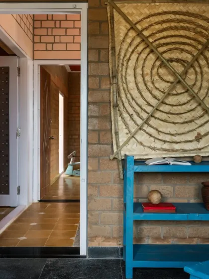 In our EESHA residence project, we used Compressed Stabilized Earth Blocks (CSEB) for the walls. These unburnt mud bricks provide excellent thermal insulation and are a core part of our sustainable building practice. The doorway shown here features a repurposed frame salvaged from a demolished home, giving a new life to old materials.