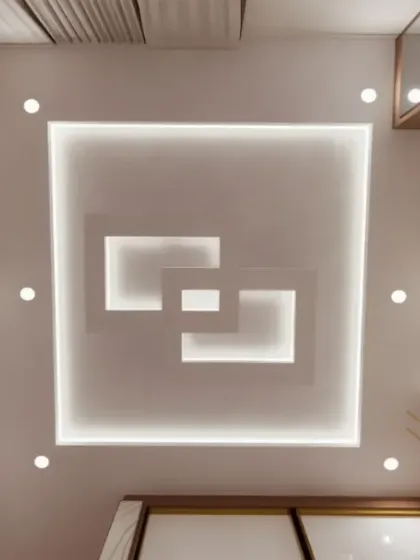 A modern, multi-layered square false ceiling design with integrated cove lighting.