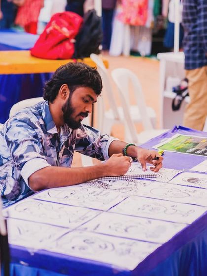 Me in the zone, focused on drawing at an outdoor event. This is my happiness.
