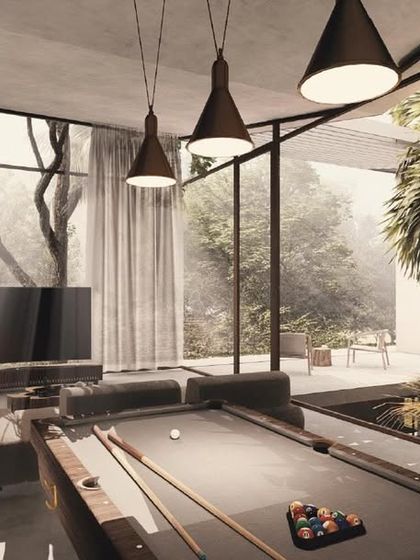 A view of the entertainment room in the House of Veils, complete with a pool table. The space is surrounded by glass, looking out onto internal courtyards and lush greenery, making it feel open and connected to nature.