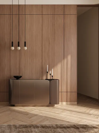 A sleek, modern console table against a warm, wood-paneled wall, showing the blend of different styles and materials within the same project.