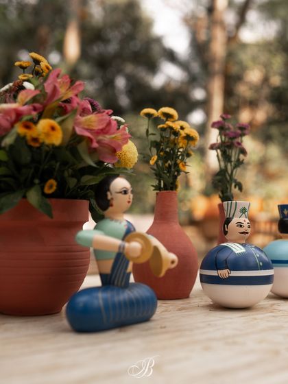 A close-up of the charming Channapatna dolls and terracotta vases used as table centerpieces. These small details, filled with local artistry, make a big impact on the overall guest experience.