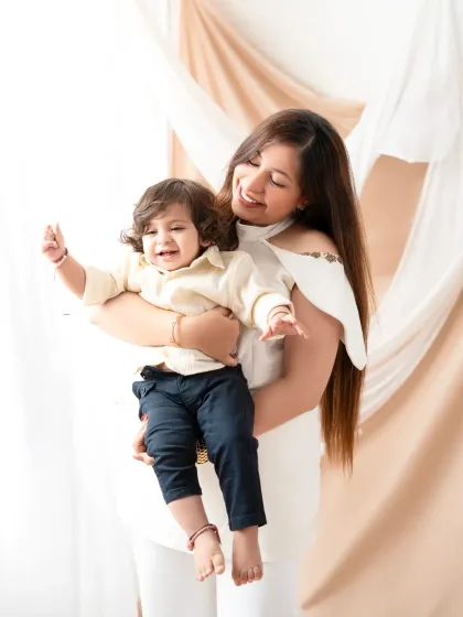 A mother's love shines in this candid moment with her son. Her joyful expression as she holds him captures the pure happiness and affection that defines their bond.