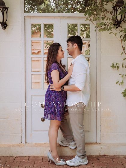 An intimate moment for a couple in front of a rustic white door.