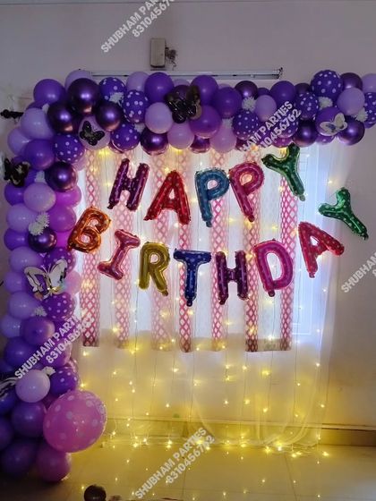 A colorful "Happy Birthday" wall decoration with a light-up backdrop.