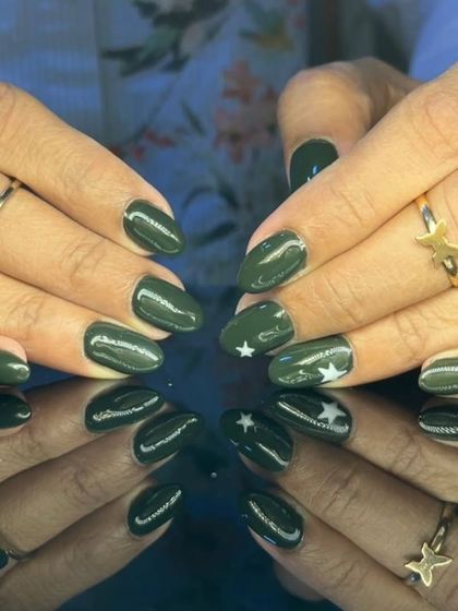 A full view of the stylish olive green and white star nail art.