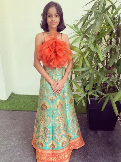 A full-length view of this adorable and unique kid's outfit. The combination of a traditional brocade skirt and a contemporary top makes it perfect for any festive occasion.