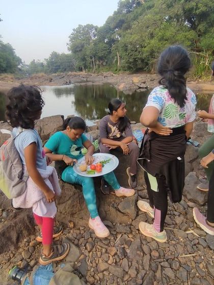 Enjoying a self-cooked meal on the rocks by the river, a proud moment for our young chefs.