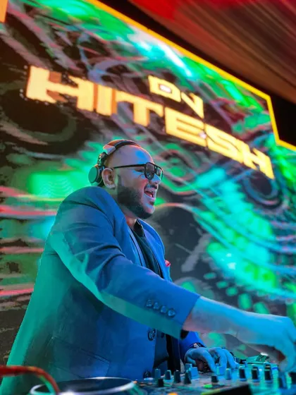 A journey filled with music and love. A side profile shot of me mixing, with a stunning, colorful LED graphic lighting up the background.
