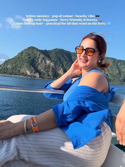 The yellow sunnies add a fun pop of color to this blue and white outfit, creating a cheerful and beachy vibe. The comfy wide-leg pants are ferry-friendly and breezy.