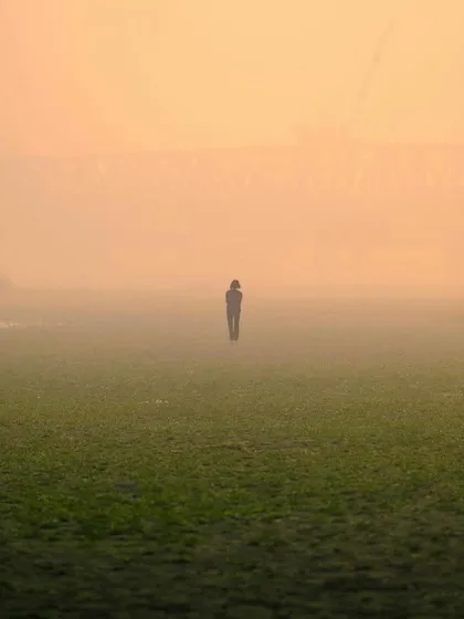 A minimalist and atmospheric shot of a solitary figure walking through a foggy field. This image was featured in my photographer spotlight.
