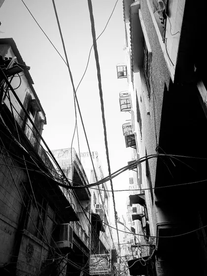 Looking up at the tangled web of wires and old buildings that characterize Old Delhi's lanes. This artistic shot captures the beautiful chaos of the city's oldest neighborhood.
