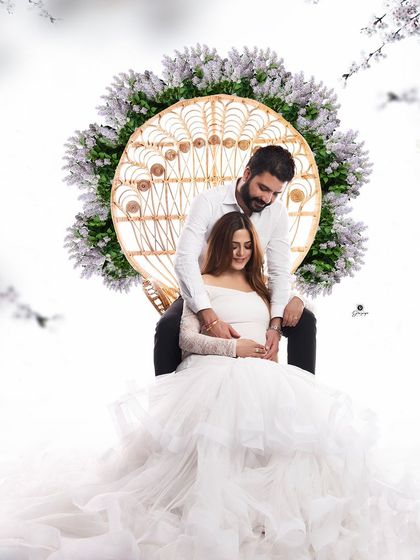 A stunning and regal portrait of a couple with the boho peacock chair. The ethereal white gown and floral accents create a magical and romantic atmosphere for this family-to-be.