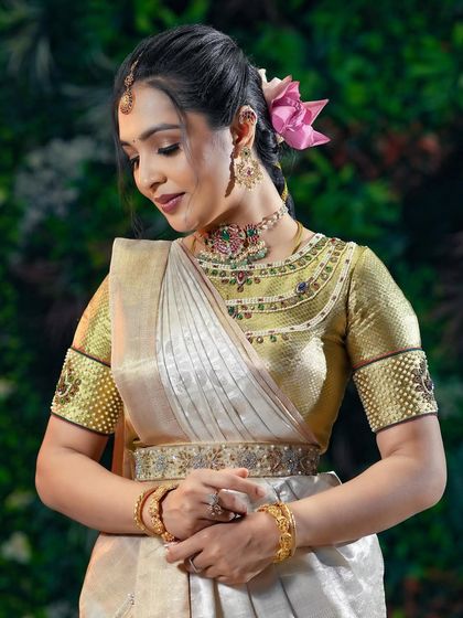 A detailed shot of the makeup, blouse embroidery, and jewelry.