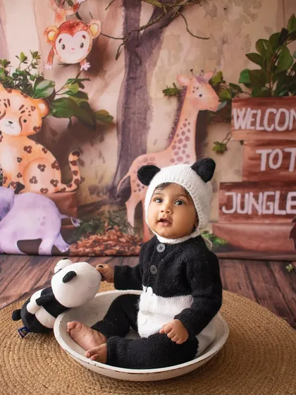 Let's have some fun with themed shoots. This little one became the cutest panda in a playful jungle setup, complete with animal friends and a cozy panda outfit.