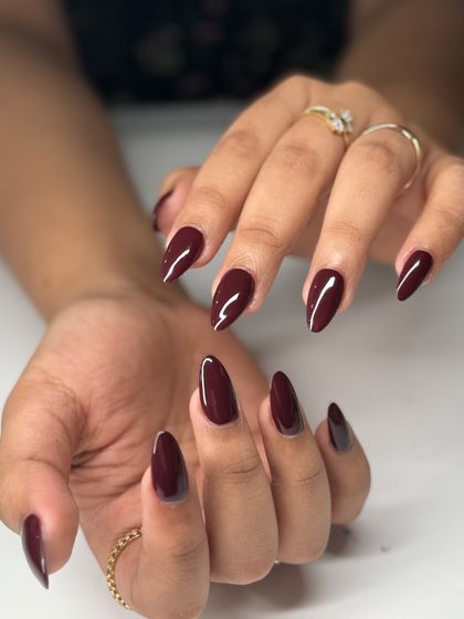 A deep, vampy burgundy on sharp almond nails. This color is sophisticated, powerful, and perfect for making a statement.