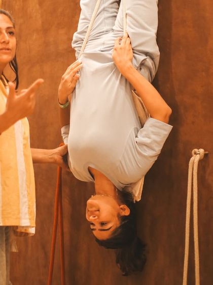 A student hangs in a supported inversion on the yoga wall. This practice is excellent for spinal health and provides a new perspective, both physically and mentally, which is a core part of our teaching.