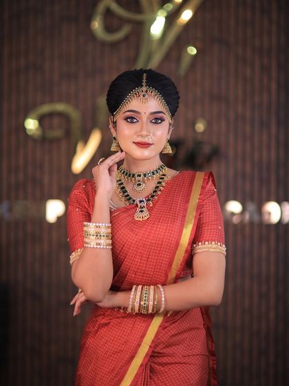 Model Swetha in a red checked silk saree. This traditional drape is perfect for showcasing classic South Indian bridal looks for catalogues or campaigns.