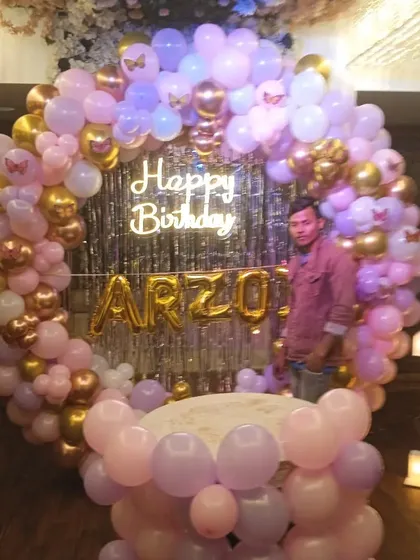 The same elegant first birthday setup, showing the full scale of the balloon ring backdrop.