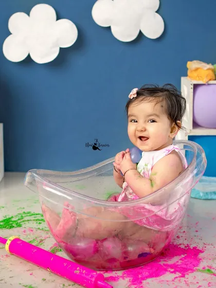 Giggles in the tub. This happy baby is all smiles during her post-Holi splash, creating a perfectly joyful memory.