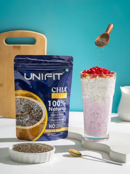 An action shot for Unifit's Chia Seeds, showing them being sprinkled into a smoothie. This image combines product photography with a dynamic element to demonstrate how the product can be used in a healthy, appealing way.