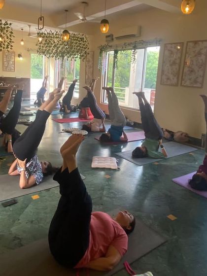 Students practicing Viparita Karani, or legs-up-the-wall pose, a gentle inversion to calm the nervous system.