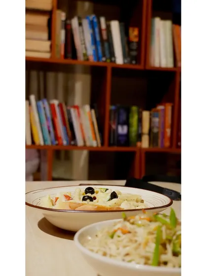 A delicious bowl of pasta and noodles, with our library in the background. It's the perfect combination of comfort food and a cozy, intellectual atmosphere.